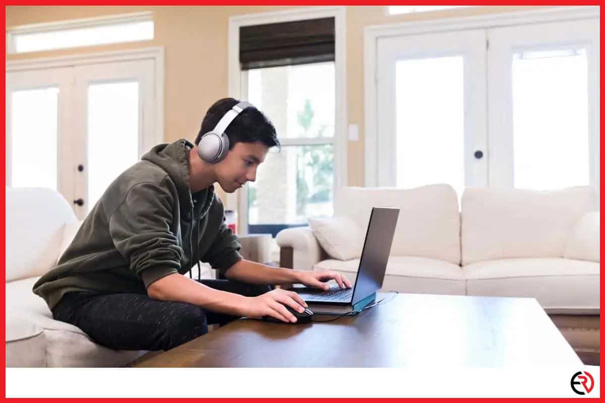 Young man using a laptop with Bluetooth headphones