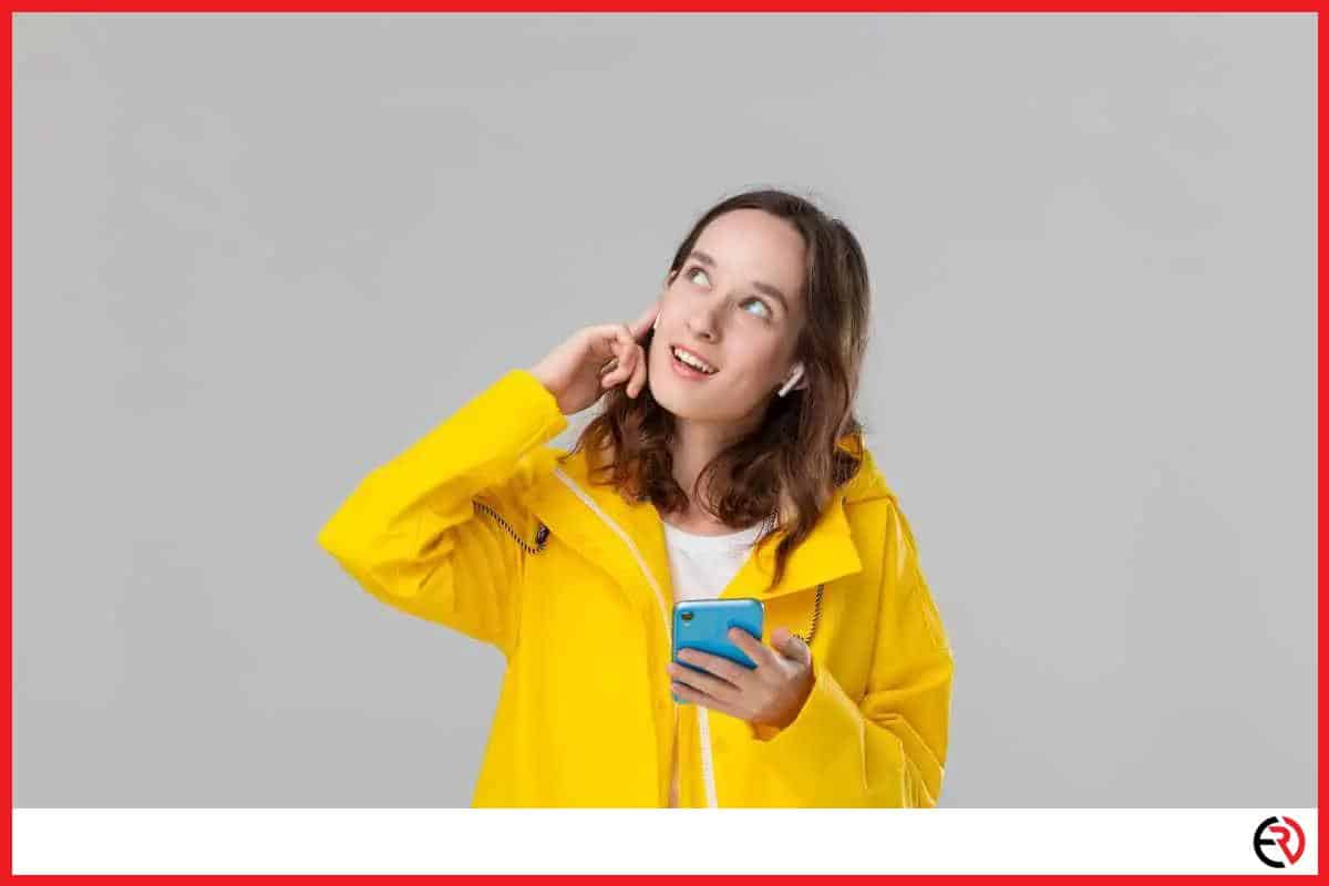 Woman with earbuds wearing a rain coat