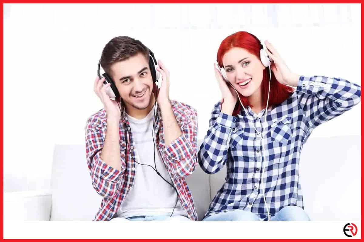 A couple sitting on a couch with headphones