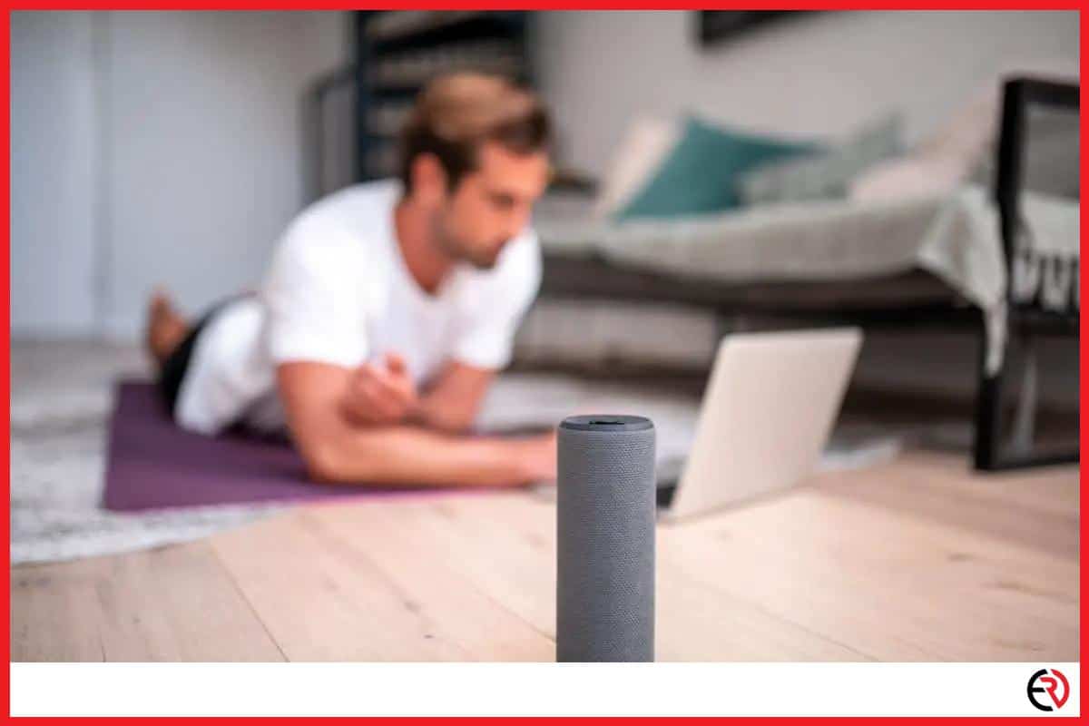 Bluetooth speaker on the floor with a young man in the backround